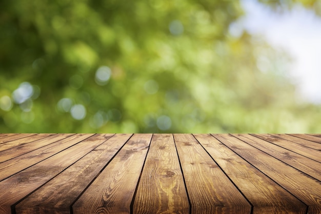 Wazig abstracte groene bokeh en houten tafel achtergrond.