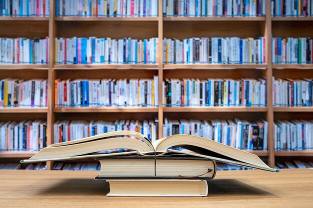 Wazig boekenplanken en boeken op het bureau. Onderwijs concept.