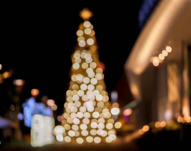 Wazig en bokeh weergave van kerstboom en versier led-verlichting voorkant van winkelcentrum op kerstnacht in stedelijke stad.