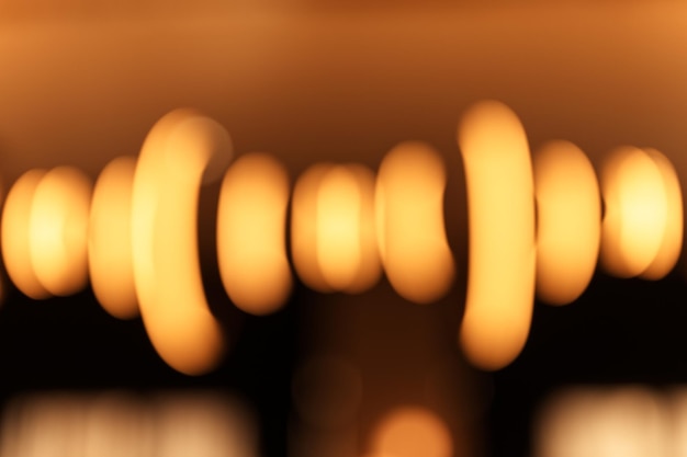 Foto wazig hangende lamp lamp in de vorm van ringen vervagen prachtige abstracte verlichting onder het plafond van moderne hanger elektriciteit ronde lampen kroonluchter gloeiend goudgeel zwak licht in een kamer