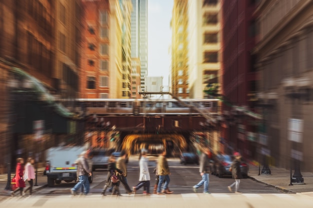 Wazig menigte van Chicago straat met verkeersweg kruising in spitsuur onder moderne gebouwen