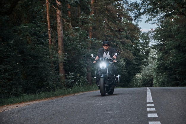 Wazige beweging een jonge man fietser in een helm rijdt snel met hoge snelheid op een bosweg in beweging