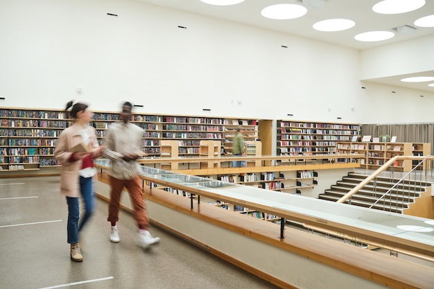 Foto wazige beweging van mensen die door de gang lopen in de grote bibliotheek