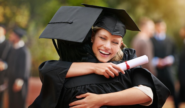 we are finally here two college graduates hugging one another in congratulations