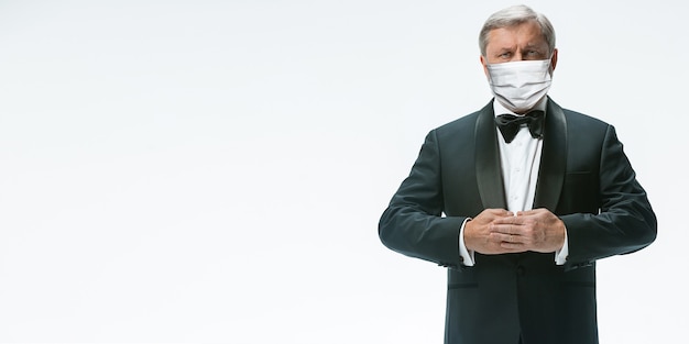 We are open. Elegance senior man waiter in protective face mask on white background. Flyer with copyspace. Cafe, restaurant opening. Safety during coronavirus pandemic. Taking care of guests, clients.