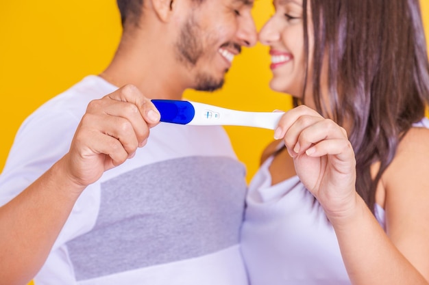 We become parents Couple feeling happy after taking a home pregnancy test I'm pregnant Happy young couple with pregnancy test Joyful couple with positive pregnancy shown in the test device