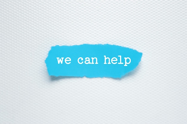 WE CAN HELP text on white background blue torn paper