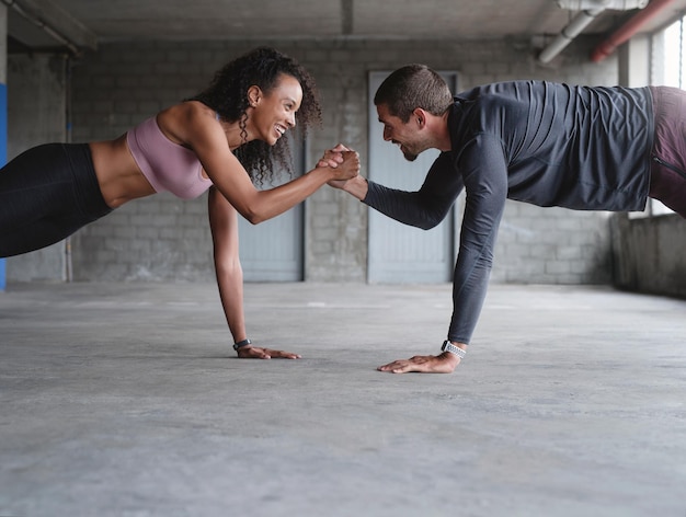 We can withstand anything together Shot of a sporty young couple holding hands while exercising together inside an underground parking lot