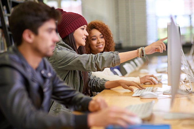 Foto potremmo includerlo nel nostro compito foto di studenti che lavorano al computer in una biblioteca universitaria