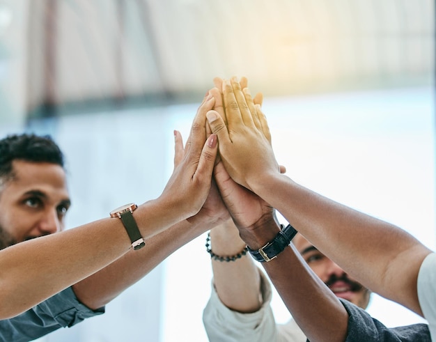 Photo we did it guys shot of a group of coworkers high fiving each other