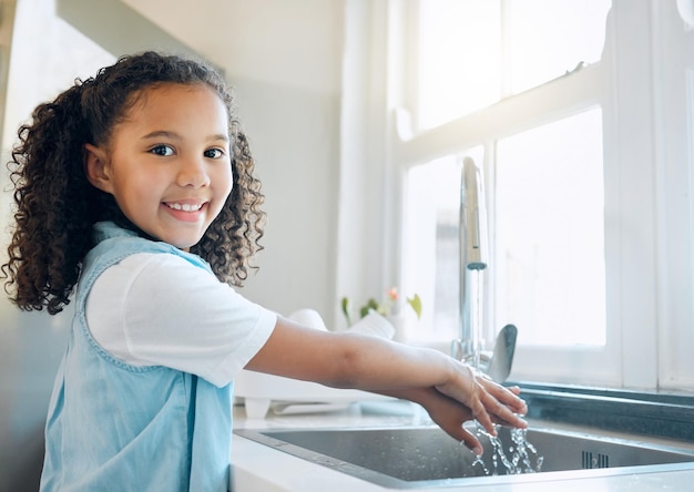 We dont want to risk getting sick now do we Shot of a little girl washing her hands in the kitchen sink at home