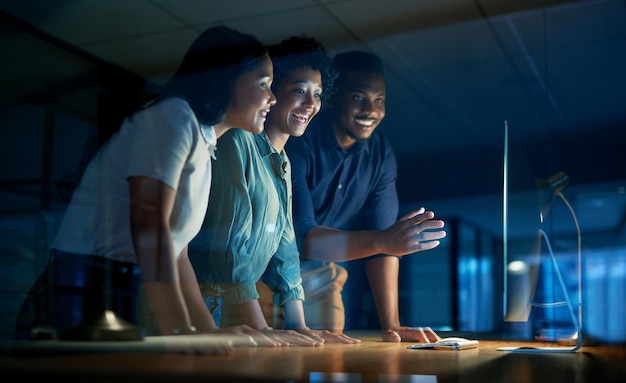 We get what we give our time to Shot of a group of young businesspeople using a computer together during a late night at work