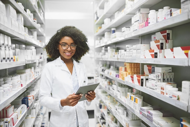 Photo we have all the medication anybody would ever need portrait of a cheerful young female pharmacist standing with a digital tablet while looking at the camera in a pharmacy