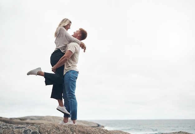 We hebben elkaar ontmoet waar de lucht de oceaan ontmoet shot van een jong stel dat de dag samen op het strand doorbrengt