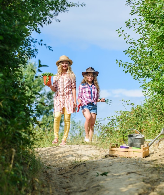 We houden van bloemen kleine meisjes boer in dorp ecologie en milieubescherming kinderen houden tuingereedschap aarde dag zomer familie boerderij landbouw en landbouw lente platteland