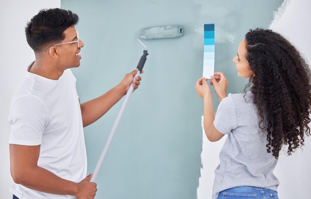 Photo we just love a diy project. shot of a young couple looking at a color swatch while busy renovating a house.