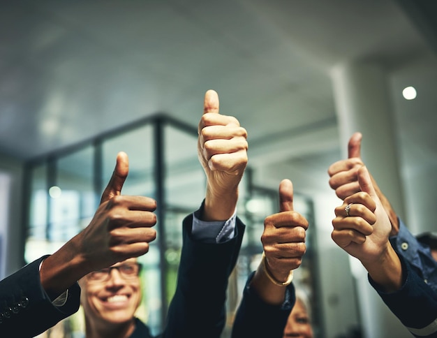 We like it a lot Closeup shot of a group of unrecognizable businesspeople showing thumbs up in an office