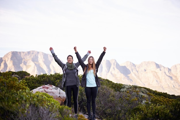 Photo we made it to the top portrait of two excited young female hikers in the outdoors