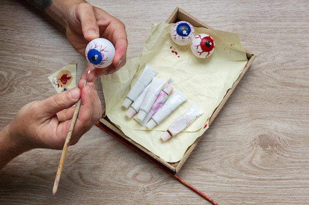 We make a decor for Halloween, paint an eyeball on a tennis ball with paints. DIY crafts with childr