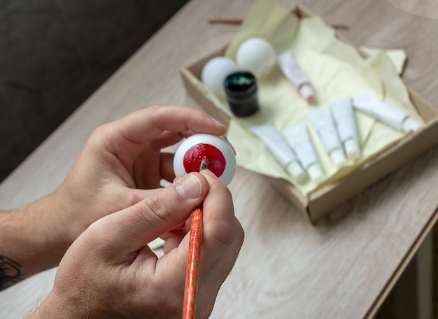 We maken een decor voor Halloween, schilderen een oogbol op een tennisbal met verf. DIY knutselen met kinderen