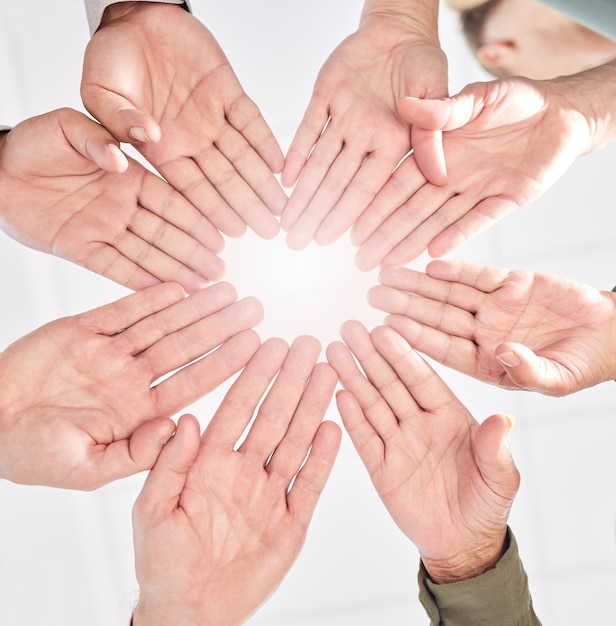 We move as a unit shot of a group of business people with their\
hands together in a circle