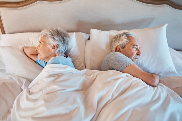 Photo we still have our little arguments cropped shot of an unhappy senior couple lying away from each other in bed during a disagreement at home