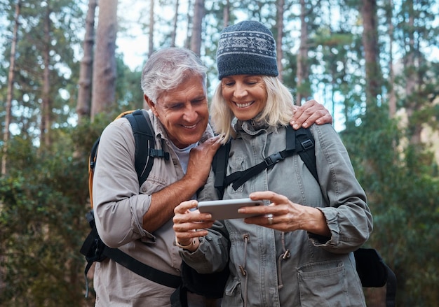 We took some great pictures. Shot of a mature couple using a cellphone while out on a hike together.