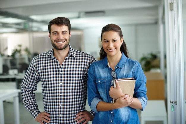 We vormen een geweldig team Portret van twee collega's die op kantoor staan