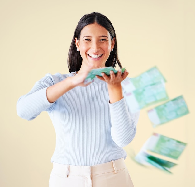 Wealthy rich and happy woman throwing money smiling about her financial success and freedom Portrait of an excited young female having fun and enjoying her cash and ready to spend