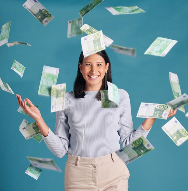 Wealthy rich and money rain or falling from the sky for financial success and growth Portrait of a successful happy and excited female catching cash and enjoying finance investment or lottery win