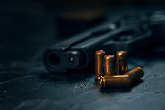 Weapons on concrete background closeup of gunpoint and bullets on table pistol for defense or attack...