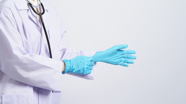 Photo wearing gloves asian doctor wear blue rubber nitrile hands glove doc with a mask putting on gloves