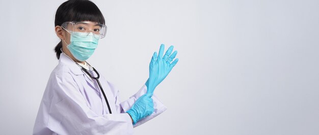 Wearing gloves Asian doctor wear blue rubber nitrile hands glove Doc with a mask putting on gloves