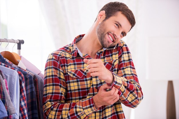 Photo wearing his favorite shirt. handsome young man wearing shirt and talking on the mobile phone