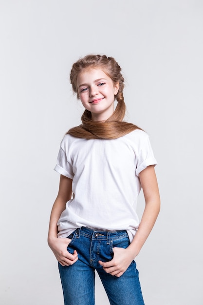 Wearing ordinary outfit. Pleasant pretty girl with healthy long hair being happy while posing for camera and smiling