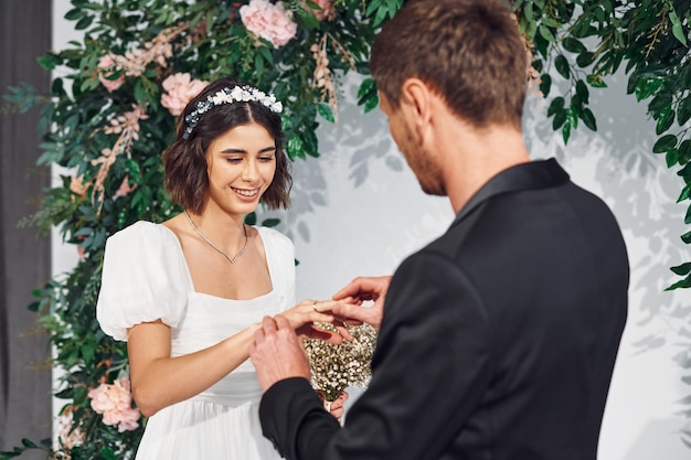 Wearing the rings Beautiful bride with his fiance is on the wedding