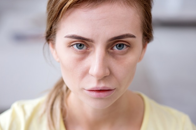 Photo weary face. portrait of a pale exhausted woman looking at you while being ill