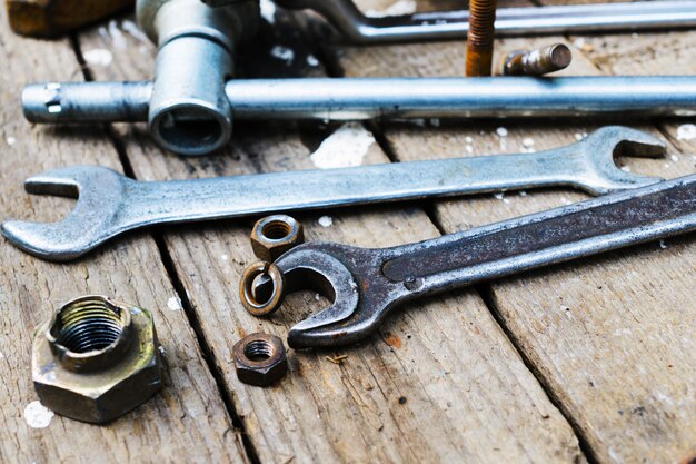 On weathered old wooden surface lie the , oily wrenches.