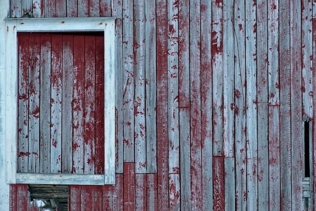 Weathered red wooden wall with window