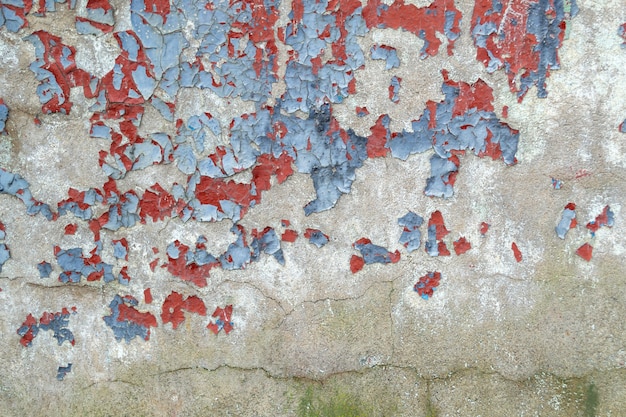 Weathered wall with chipped blue and red paint. Old colored concrete wall. cracked texture, abstract