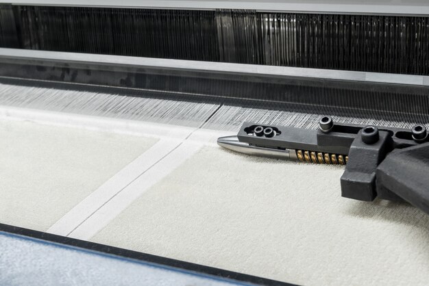 Weaving loom at a textile factory, closeup. industrial fabric production line