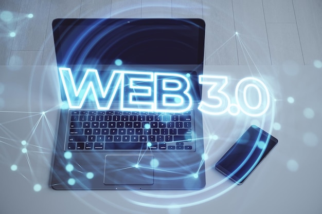 Web 30 블록체인 및 AI 현대 기술을 사용하는 차세대 인터넷 IoT 바탕 화면에 홀로그램이 있고 배경이 흐릿한 노트북과 스마트폰 클로즈업 이중 노출