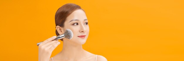 Web banner happy young asian woman hold makeup brush