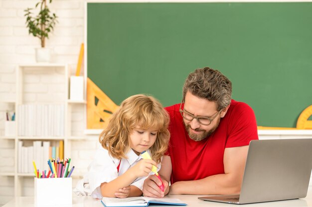 Webinar videoles online onderwijs op laptop vader en zoon gebruiken moderne communicatietechnologie