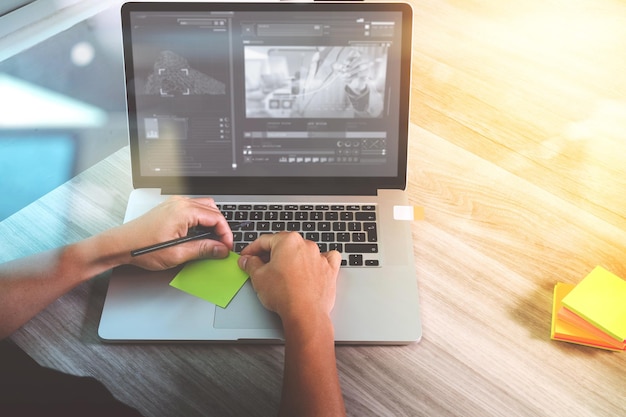 Website designer hand attending video conference with laptop computer and memo note paper