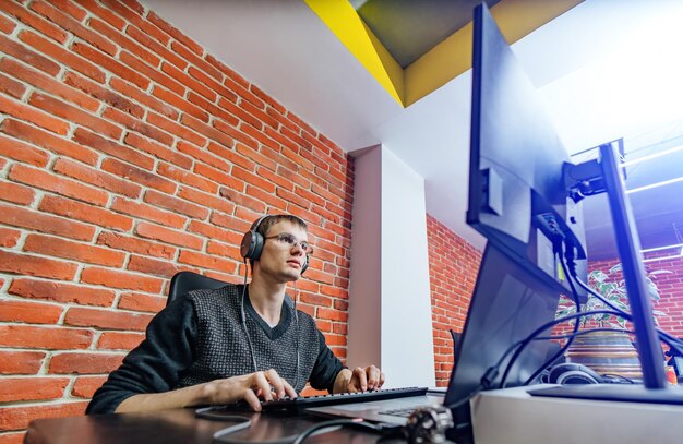 Website ontwerp programmeer- en coderingstechnologieën Man aan het werk in de buurt van computer Man in koptelefoon Creatief kantoor