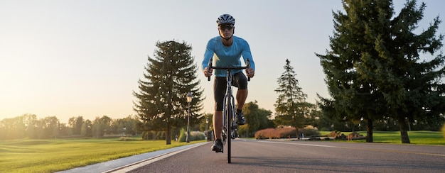 Websitekoptekst van bijgesneden opname van een man die op een mountainbike in het park rijdt tijdens zonsondergang