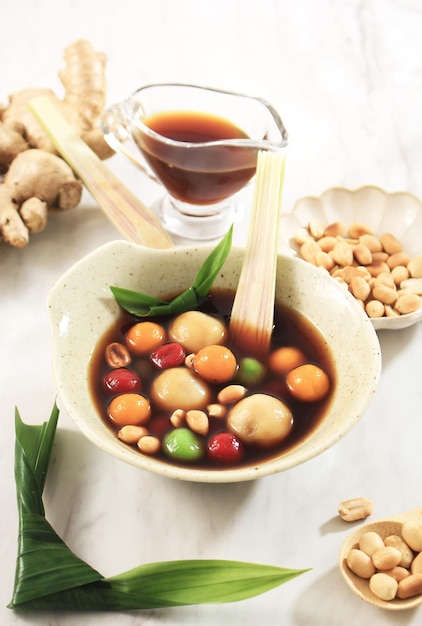 Wedang Ronde (Tangyuan) или клецки из сладких шариков в сиропе с имбирем и пальмовым сахаром. Топпинг с жареным арахисом. Копировать пространство, выбранный фокус