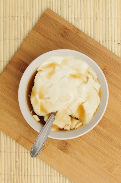 Wedang Tahu or Kembang Tahu traditional dessert made of soybean pudding with palm sugar and ginger syrup