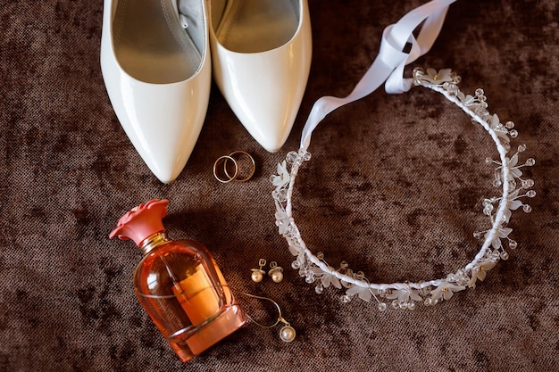 Wedding accessories. White patent leather shoes for women, earrings and a pendant on a chain